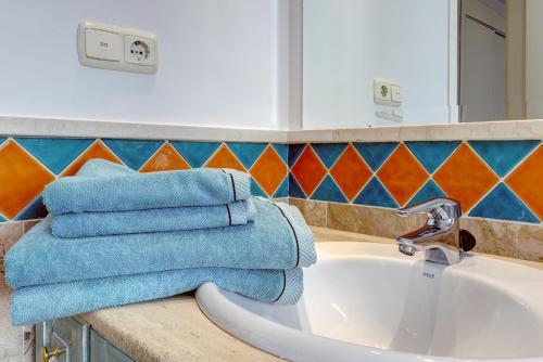 uma casa de banho com toalhas azuis num lavatório em Banana Beach primera línea de playa em Marbella