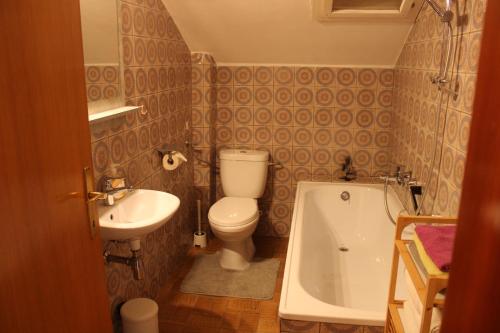 a bathroom with a toilet and a sink and a tub at Haus Waldfrieden in Sautens