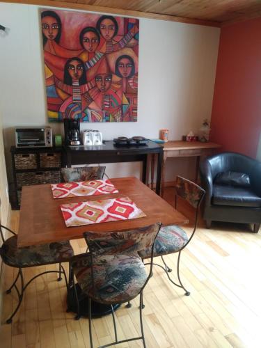 a table and chairs in a room with a painting at Gite Pousse Pioche in Notre-Dame-des-Monts