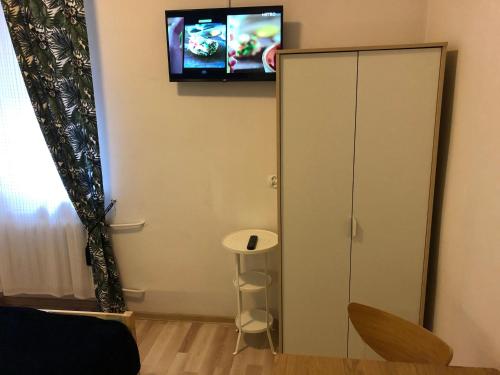 a living room with a tv on the wall at Hostel Kubik in Krakow