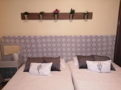 a bedroom with two beds with flowers on the wall at Ca la Glori in Los Corrales