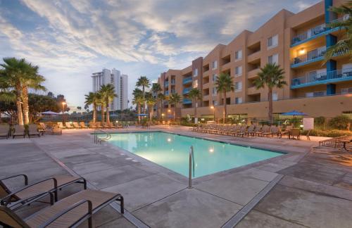 einen Pool mit Stühlen und ein Gebäude in der Unterkunft Worldmark Oceanside Harbor in Oceanside