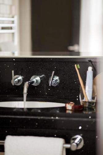 a kitchen sink with a faucet and a sink at The Clermont London, Victoria in London