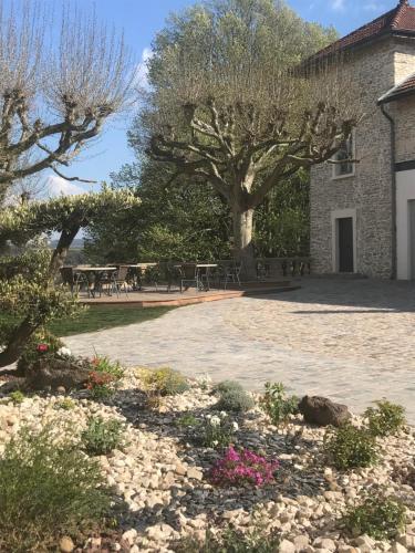 a courtyard with tables and flowers in front of a building at Castel serein in Maubec