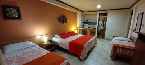 ボゴタにあるHoteles Bogotá Inn Turisticas 63のベッド2台とキッチン付きのホテルの部屋