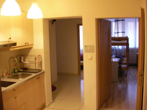 uma cozinha com um lavatório e uma porta para um quarto em Hostel Kubik na Cracóvia