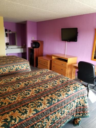 Habitación de hotel con 2 camas, escritorio y TV. en Hermitage Inn, en Hermitage