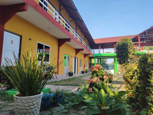 żółty budynek z roślinami przed nim w obiekcie Hospedaje Barrancas w mieście Cosoleacaque