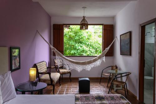 a living room with a hammock in a room at Pousada Arvoredo in Pirenópolis