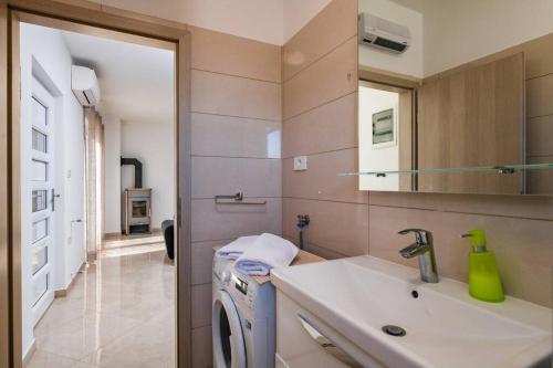 a bathroom with a sink and a washing machine at Villa Ester in Pula