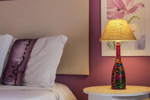 a lamp sitting on a table next to a bed at Pousada Arvoredo in Pirenópolis