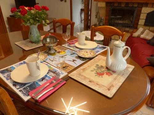 - une table à manger avec des assiettes et des tasses dans l'établissement LA Bouigane, à Saint-Lary