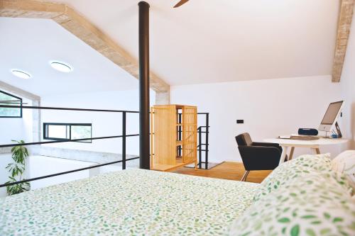 a bedroom with a bed and a desk with a computer at Casa Encina in Murcia