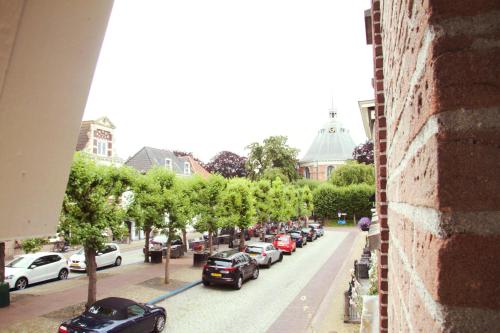 a street with cars parked on the side of the road at Hotel Willemstad in Willemstad