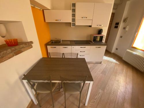 a kitchen with a table and chairs in a room at Appartamenti Mavino in Sirmione