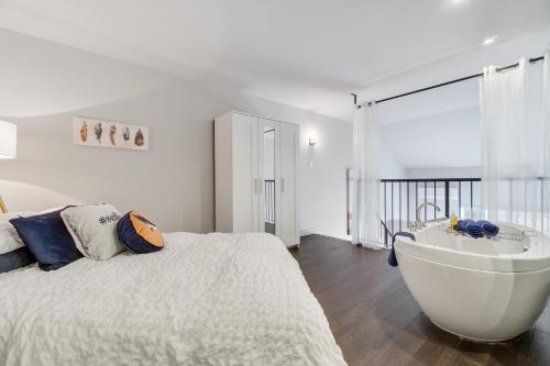 um quarto com uma cama grande e uma banheira em INITIAL - ÉVASION NATURE - Mont-Sainte-Anne em Beaupré