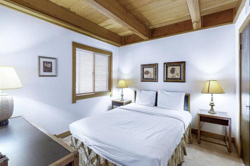 a bedroom with a white bed and two lamps at Northstar Gold Bend Retreat in Truckee