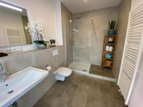 a bathroom with a shower and a toilet and a sink at Hotel Tortuga & Tex-Mex Bar & Grill in Grafenwöhr