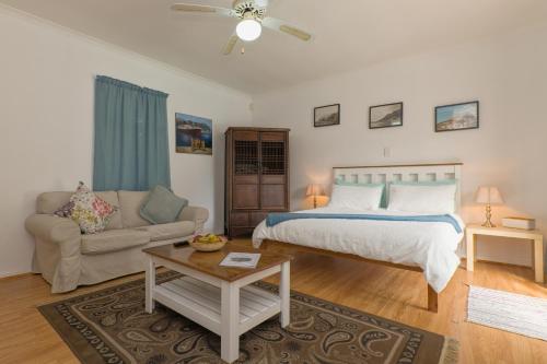 ein Schlafzimmer mit einem Bett und einem Sofa in der Unterkunft The Walmer Oasis in Port Elizabeth
