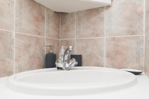 La salle de bains est pourvue d'un lavabo et d'un robinet. dans l'établissement The Walmer Oasis, à Port Elizabeth