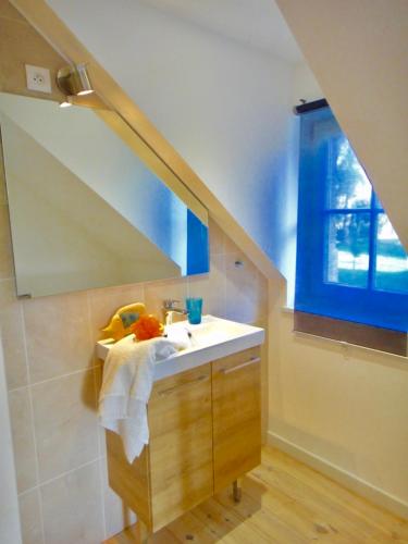 une salle de bain avec un lavabo et une fenêtre dans l'établissement Le Clos des Marronniers, à Douvres-la-Délivrande