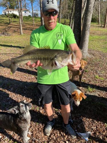 a man holding a large fish in a field at Dogwood Springs Lodgings in Mineola