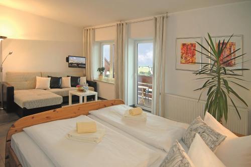 een slaapkamer met een bed en een woonkamer bij Familienhotel Brandtsheide in Jeserig
