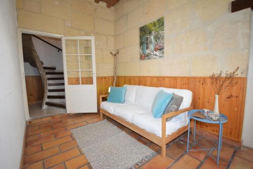 a living room with a white couch and a table at Maison Le Neuf Tarascon avec garage privé in Tarascon