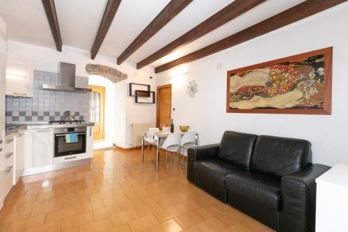 sala de estar con sofá de cuero negro y cocina en Giardi, en Riomaggiore
