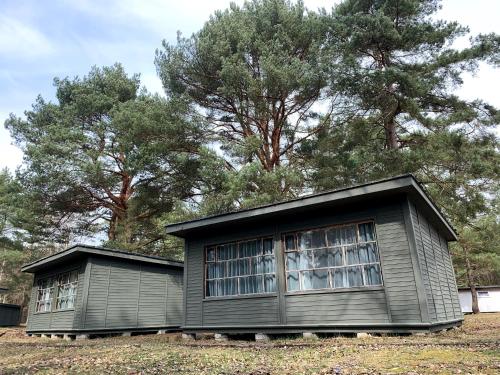 una pequeña casa con dos ventanas en un patio en Camp Bursztynowy Las, en Gdansk