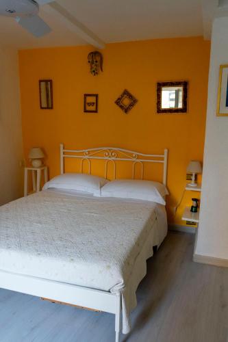 a bedroom with a white bed in a yellow wall at Solemagia in Vernazza