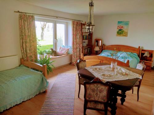 a bedroom with a bed and a table and a bed and a window at Zakątek Szczęścia Eko Agroturystyka in Kiwity