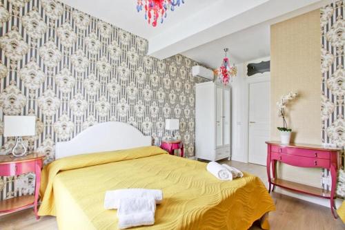 a bedroom with a yellow bed with a yellow bedspread at Hotel La Maison Delle Terme in Tivoli Terme