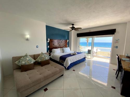a bedroom with a bed and a couch and the ocean at Mar Celeste in Manzanillo