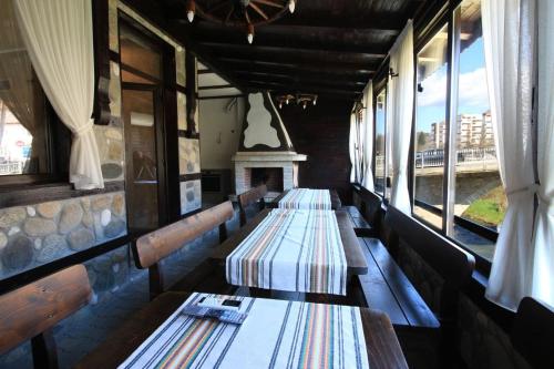 a row of benches in a restaurant with windows at Къща за гости Тони in Zlatograd