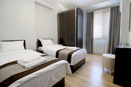 een hotelkamer met 2 bedden en een wastafel bij Къща за гости Тони in Zlatograd