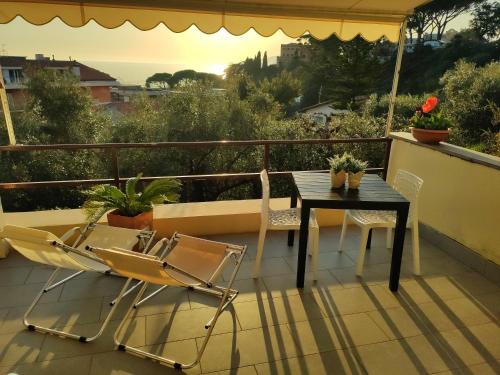 eine Terrasse mit einem Tisch und Stühlen auf dem Balkon in der Unterkunft IL LEUDO in Lavagna