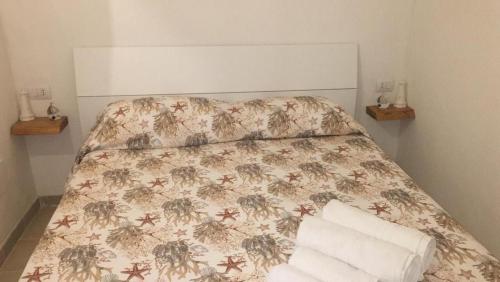a bedroom with a bed with a floral bedspread at Romì-Antica dimora in Polignano a Mare