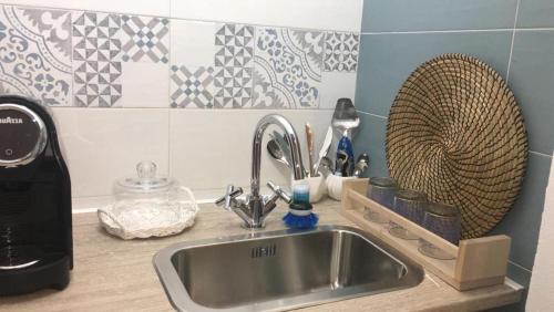 Una encimera de cocina con un fregadero y una cafetera. en Romì-Antica dimora, en Polignano a Mare