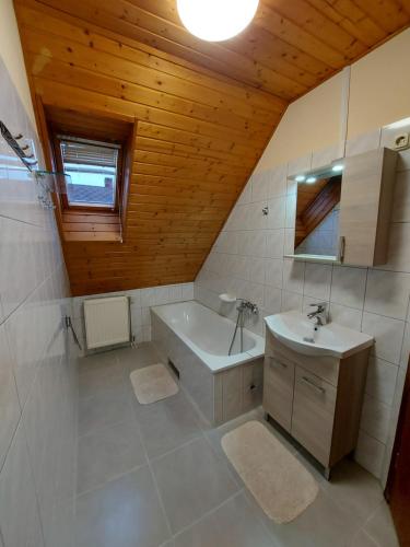 La salle de bains est pourvue d'un lavabo et d'une baignoire. dans l'établissement Aranykagyló Nyaralóház, à Bytom