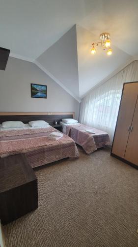 a hotel room with two beds and a tv at Art Room Sochi in Adler