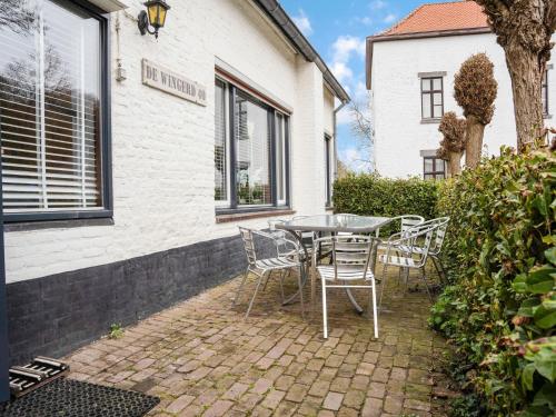 a patio with a table and chairs in front of a building at Serene Holiday Home in Ulestraten near Private Forest in Ulestraten