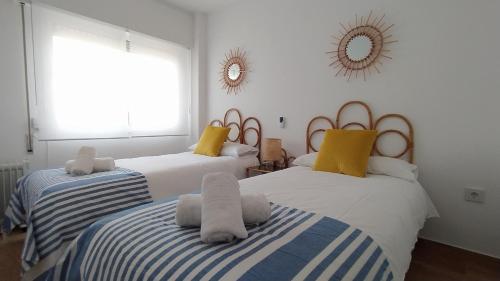 a bedroom with two beds with towels on them at AZAHAR-Playa Home by Cadiz4Rentals in Cádiz