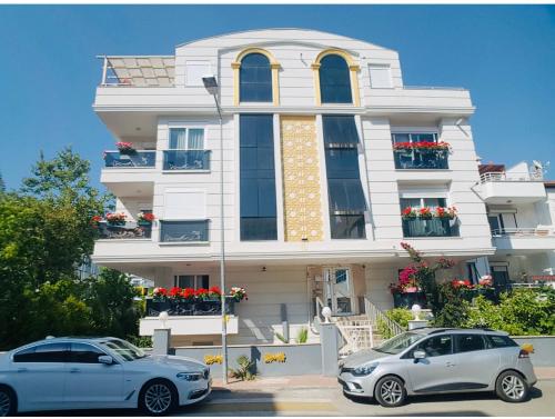 zwei Autos vor einem Gebäude geparkt in der Unterkunft Royal Loft Suit in Antalya