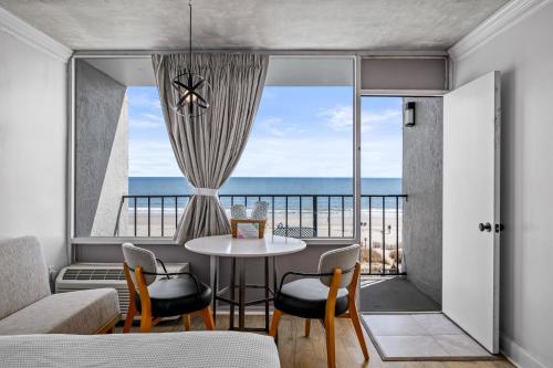 a living room with a table and a view of the ocean at The Beverley Beach House in Myrtle Beach