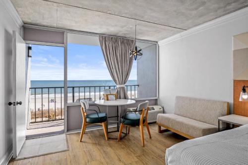 a bedroom with a table and chairs and a view of the ocean at The Beverley Beach House in Myrtle Beach