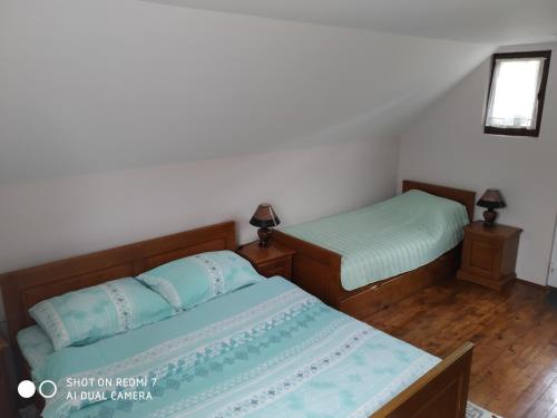 a bedroom with two beds and a mirror at Apartman Ana in Mokra Gora