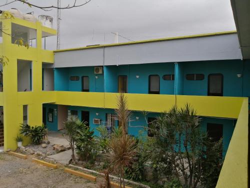a yellow and blue building with palm trees in front of it at Hotel Tamuin in Antiguo Tamuín