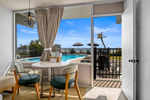 a patio with a table and chairs and a pool at The Beverley Beach House in Myrtle Beach