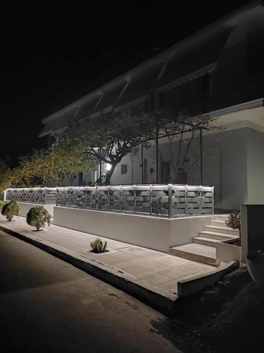 a building with a fence and stairs at night at Stefani apartments in Methana